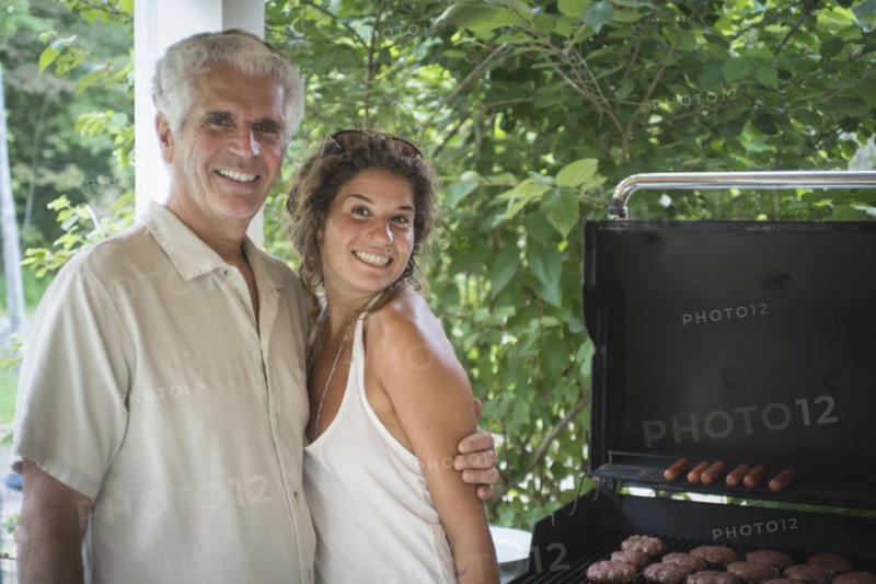 Caucasian father and daughter grilling in backyard