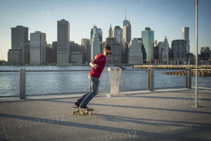 Caucasian skateboarder doing trick at waterfront