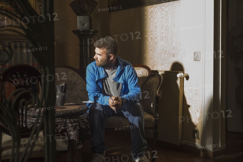 Caucasian man sitting in sunlight in living room