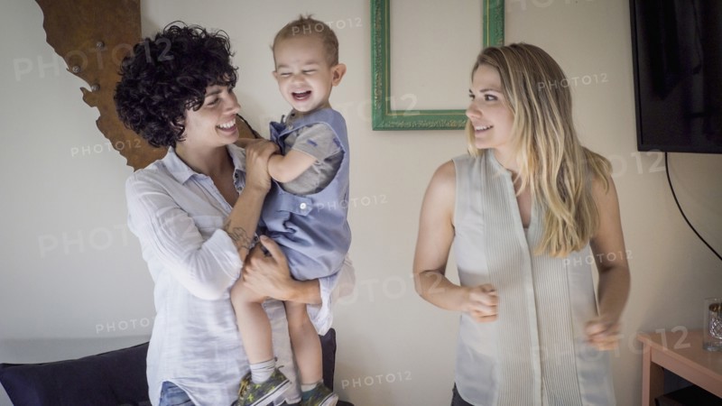 Caucasian lesbian mothers and baby son in living room
