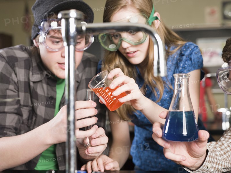 Students performing experiment in science lab classroom