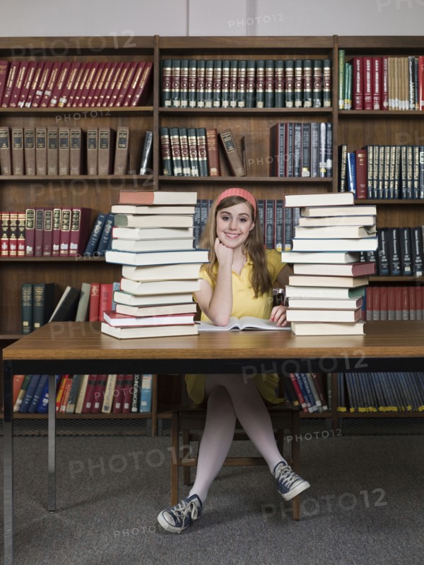 Student sitting with books in library