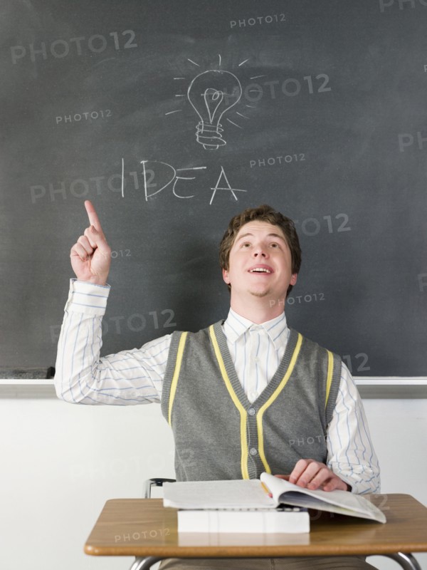 Student having idea under light bulb on chalkboard in classroom