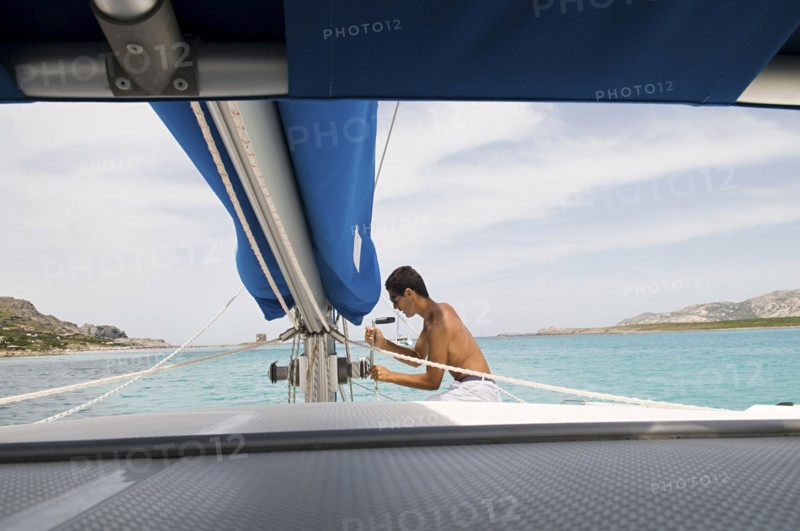 Man hoisting sailboat rigging on deck