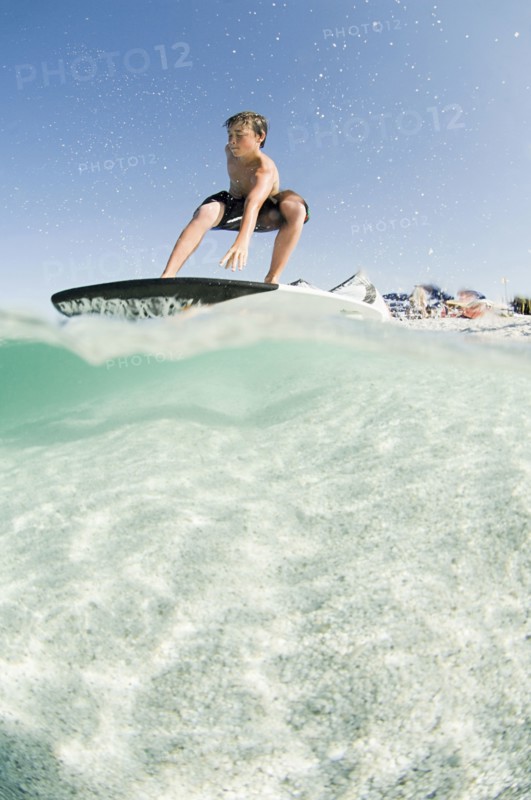 Low angle view of man standing on surfboard