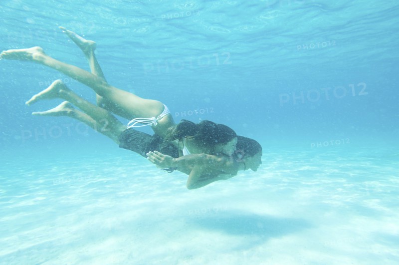 Underwater view of couple swimming in ocean