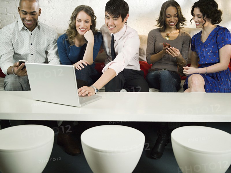 Business people using laptop in office lounge