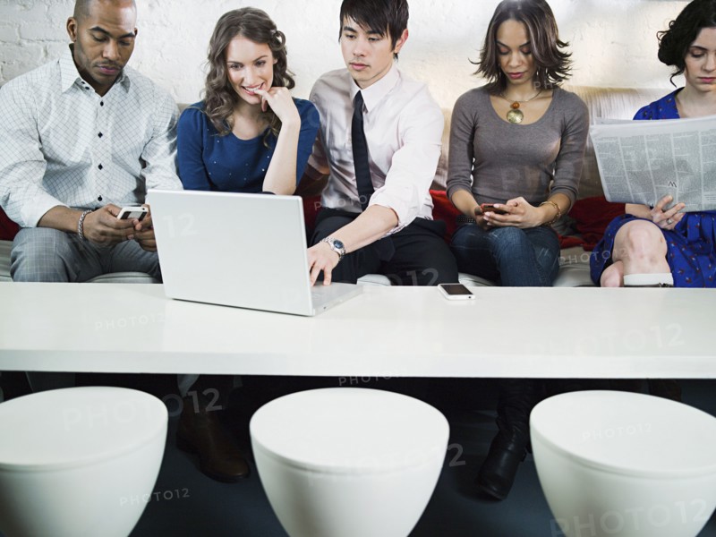 Business people using laptop in office lounge
