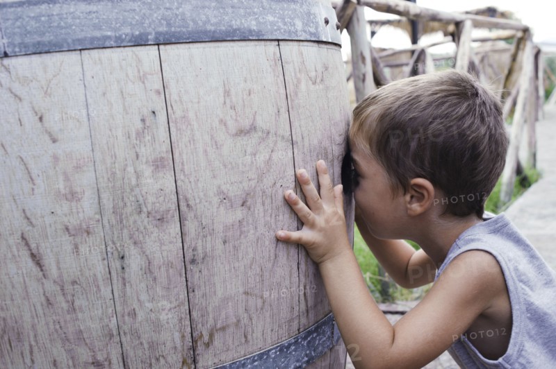 Caucasian boy peering into barrel