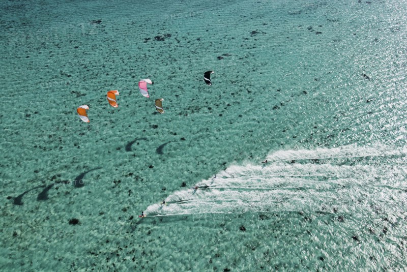 Aerial view of people kitesurfing on ocean