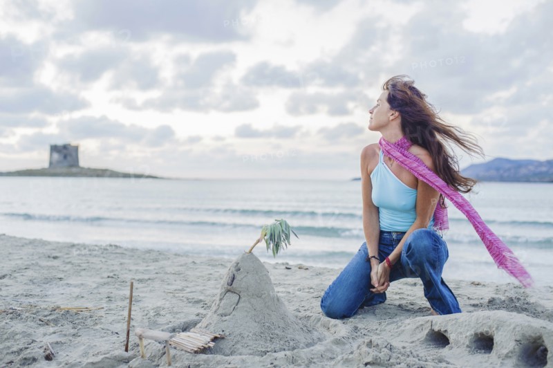 Caucasian woman building sandcastle on beach