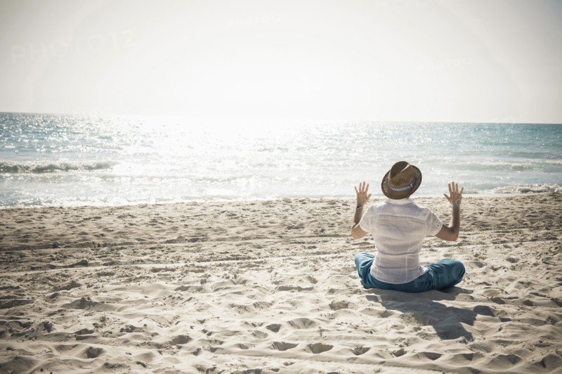 Caucasian man sitting on beach