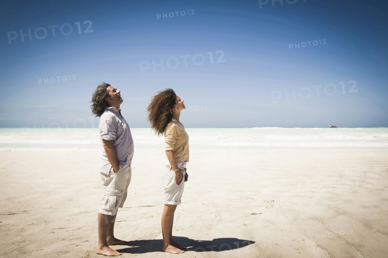 Couple standing in wind on beach