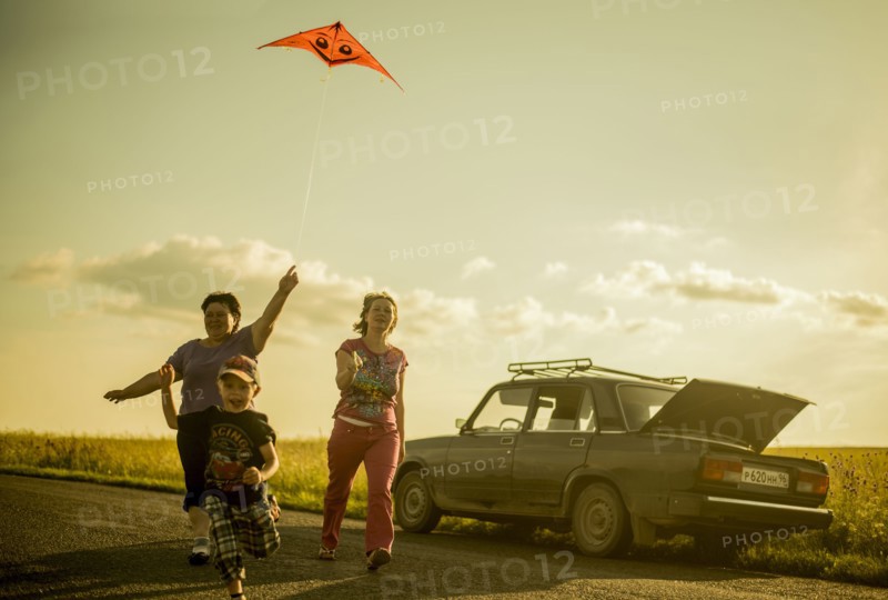 Caucasian family flying kite on rural road