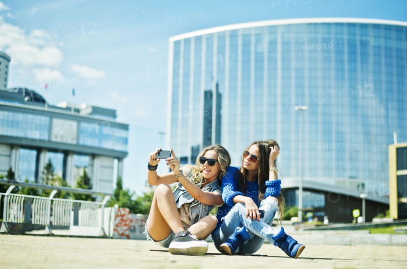 Women taking picture on city street