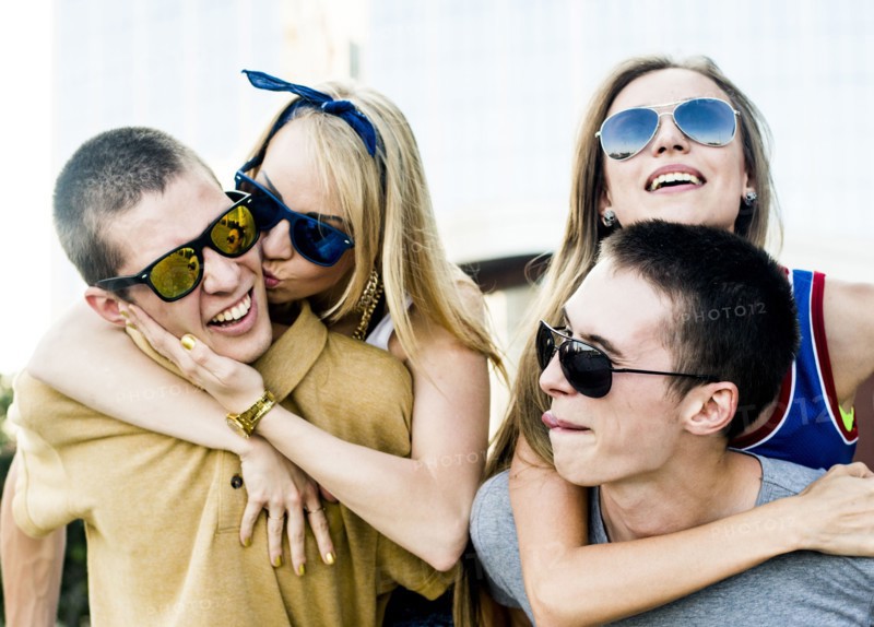 Caucasian men carrying girlfriends piggyback outdoors