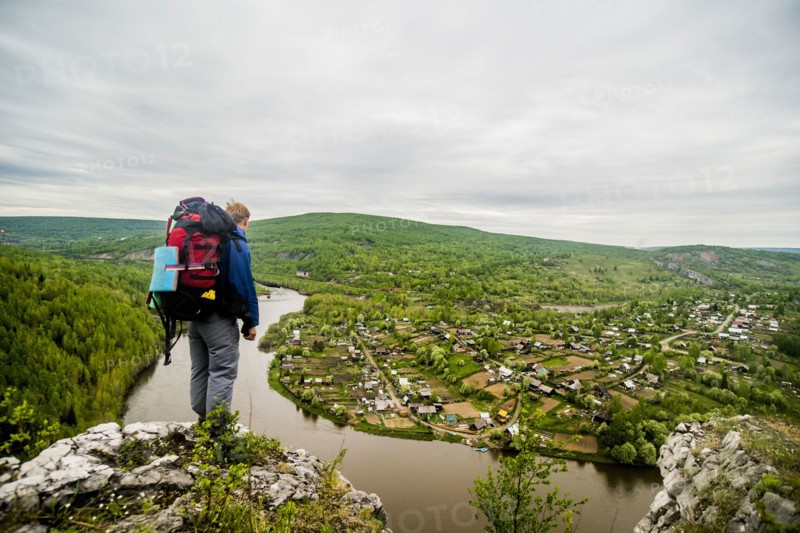 Caucasian hiker admiring scenic view of village