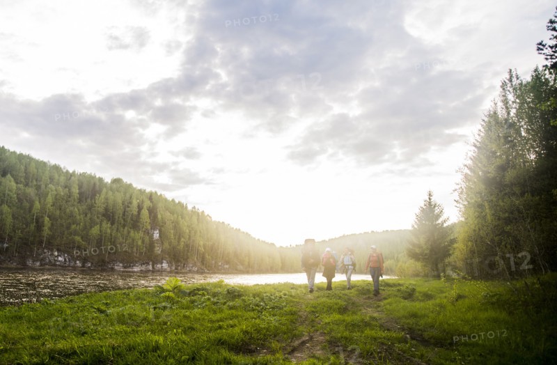 Caucasian tourists walking near river in remote landscape