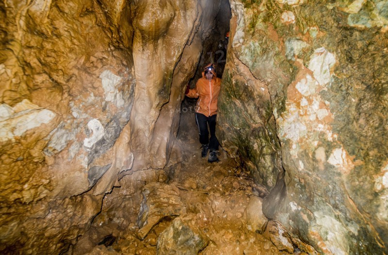 Caucasian woman exploring rock formation cave