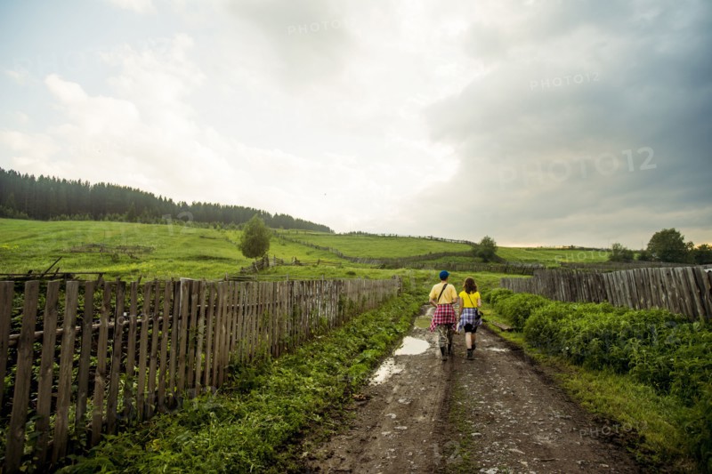 Caucasian couple walking on rural dirt road