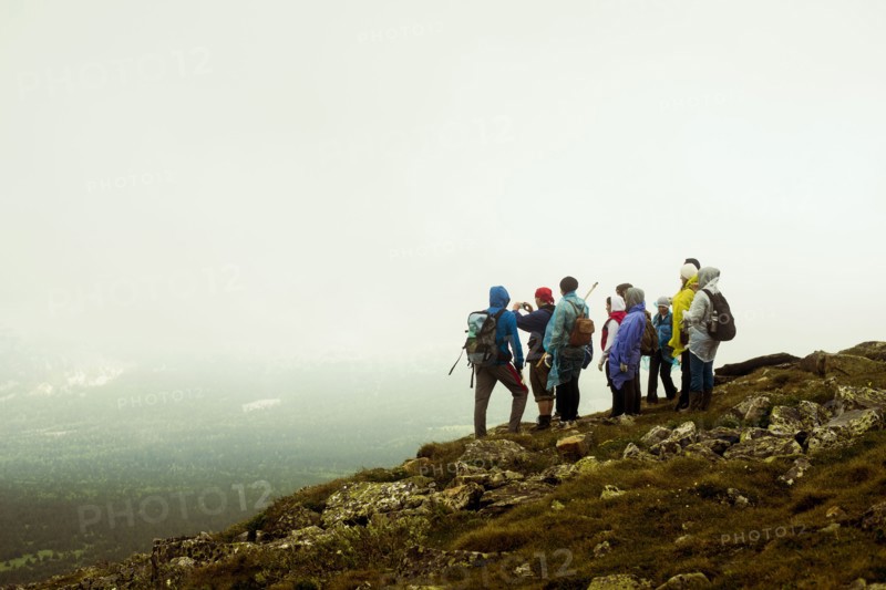 Caucasian hikers standing on rocky hilltop