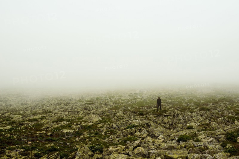 Caucasian hiker walking in rocky field