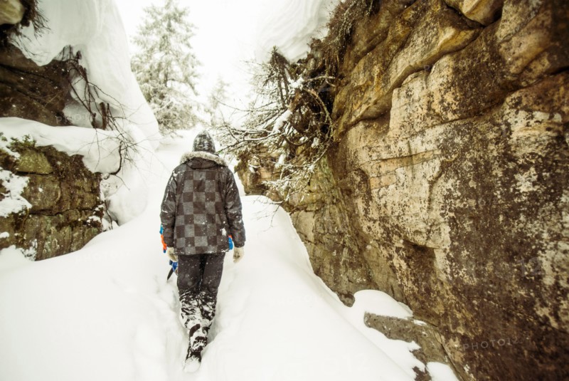 Caucasian hiker exploring snowy rock formations