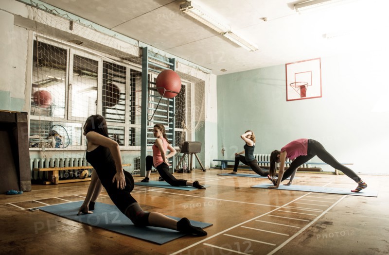 Caucasian dancers stretching in gym