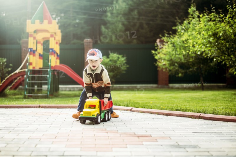 Caucasian boy playing with toy truck in playground