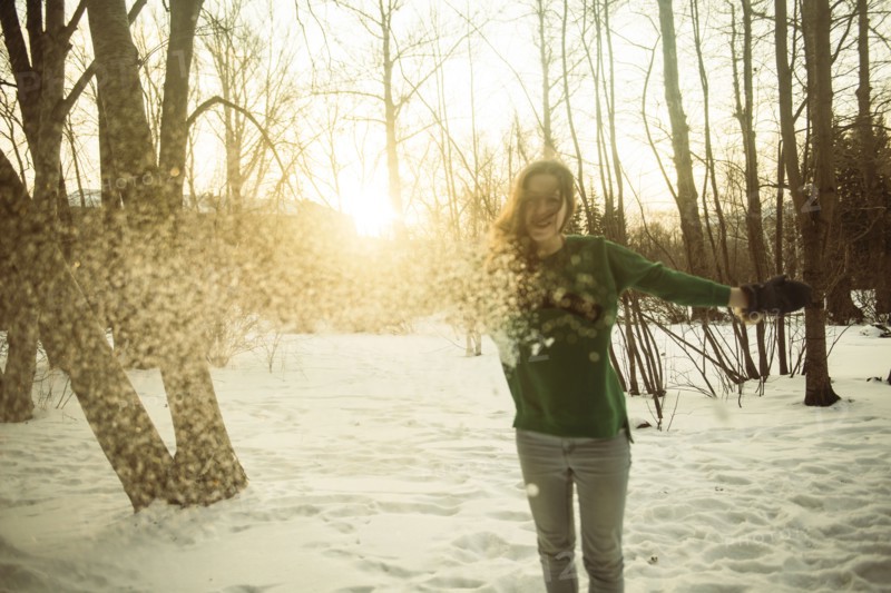 Caucasian woman playing in snowy field