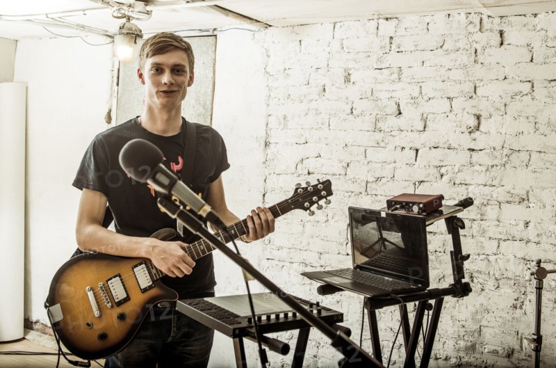 Caucasian man playing electric guitar in rock band