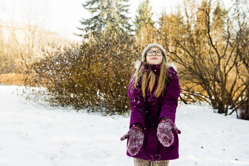 Caucasian girl looking up in snowy field