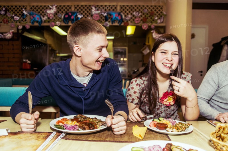 Caucasian couple laughing in restaurant