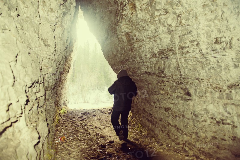 Caucasian hiker walking in rocky cave