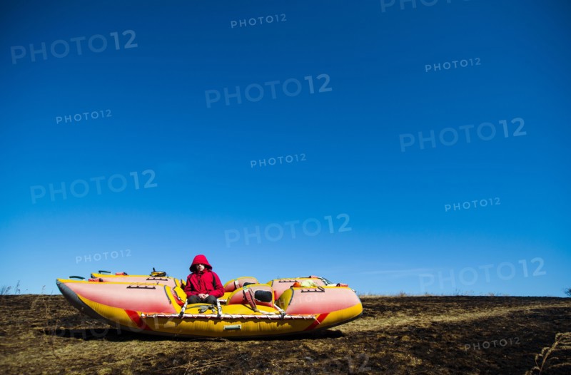 Caucasian boy sitting on catamaran in rural field