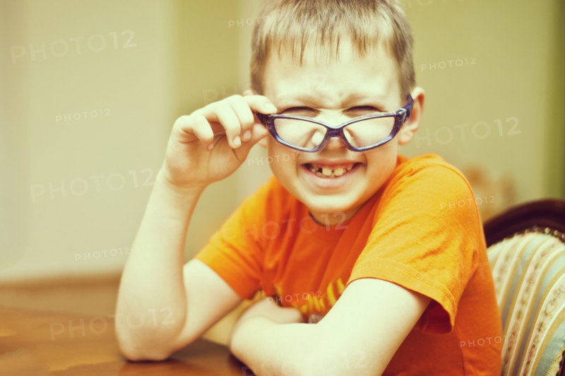 Caucasian boy peering over glasses