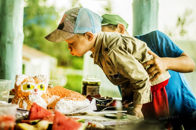 Caucasian boy blowing out candles on birthday cake