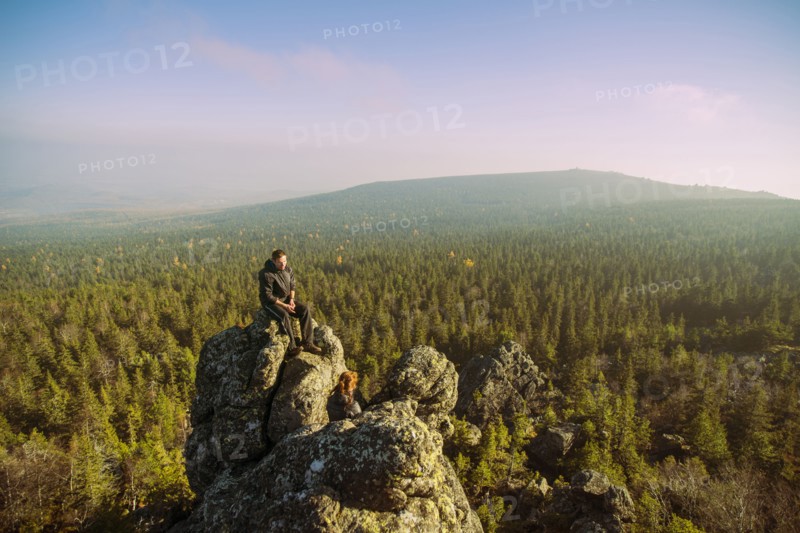 Caucasian hikers admiring view from remote rock formation