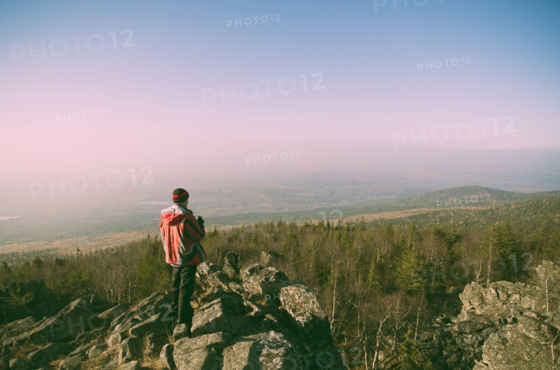 Caucasian hiker admiring view from remote rock formation