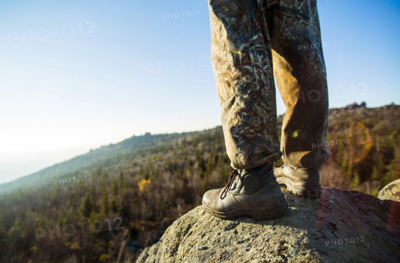 Close up of hiker standing on remote rock