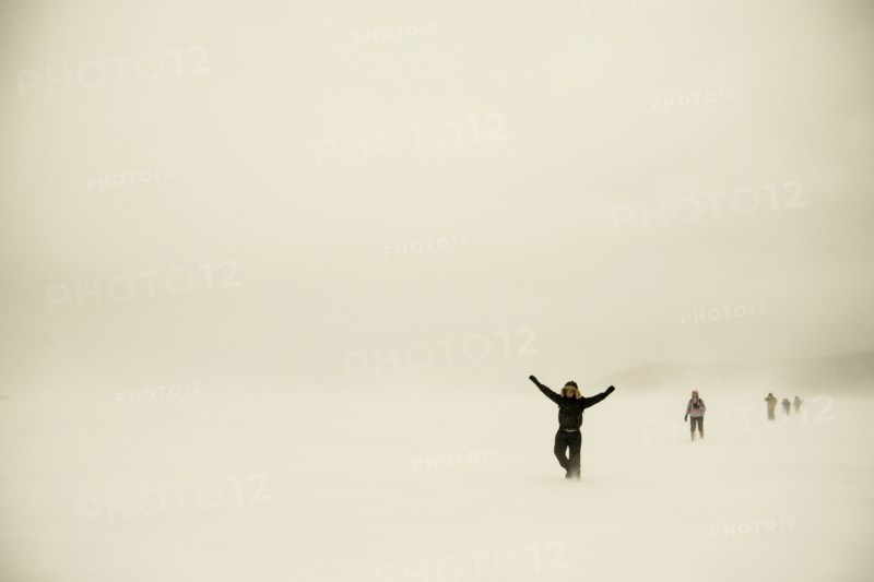 Caucasian hikers walking in snowy remote field