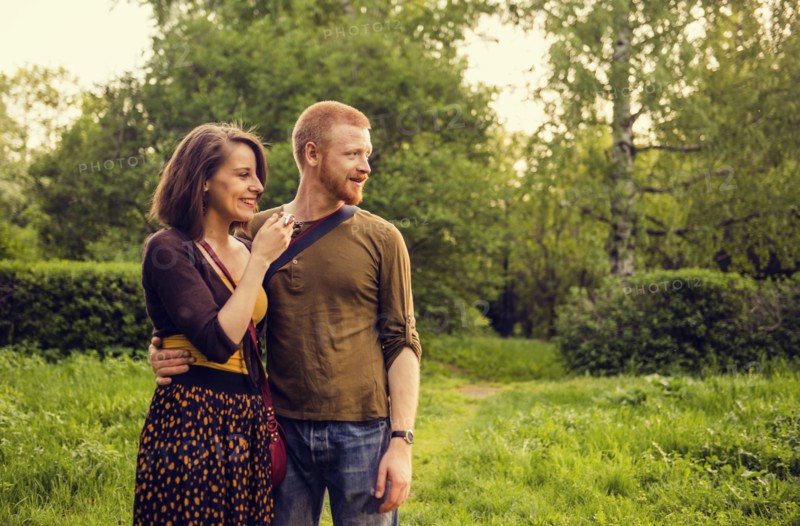 Caucasian couple hugging in field