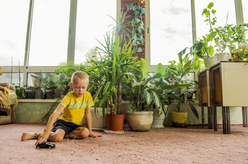 Caucasian boy playing with toy cars on floor