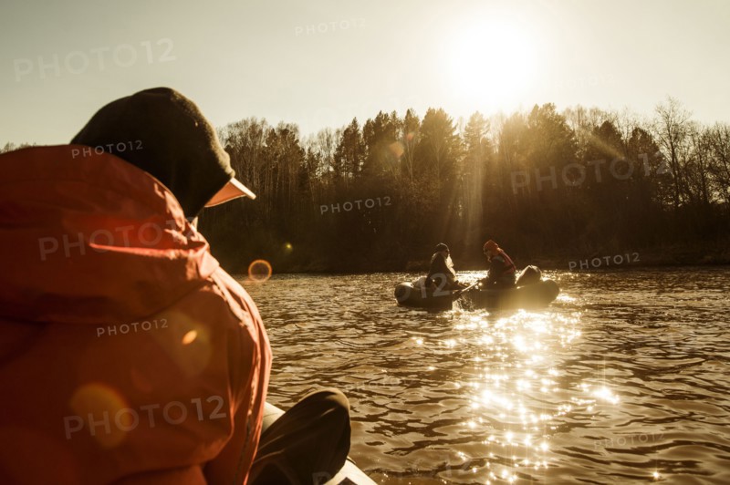 Caucasian fisherman sitting in canoe on river