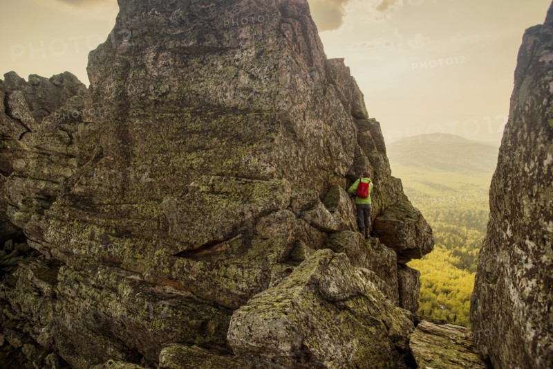 Caucasian hiker climbing on rock formation