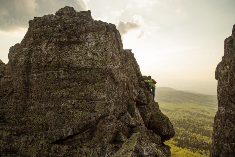 Caucasian hiker climbing on rock formation