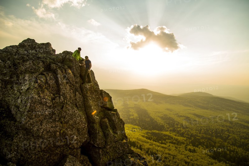 Caucasian hikers on rocky hilltop in remote landscape