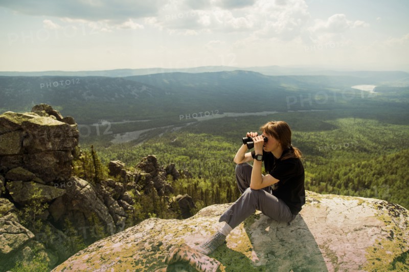 Caucasian hiker admiring remote landscape from rocky hilltop