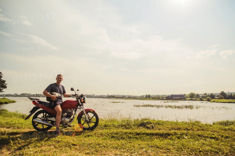 Caucasian man sitting on motorcycle in park