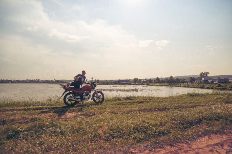 Caucasian man sitting on motorcycle in park